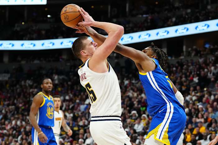 Nikola Jokic goes to shoot the basketball as Kevon Looney reaches and fouls him